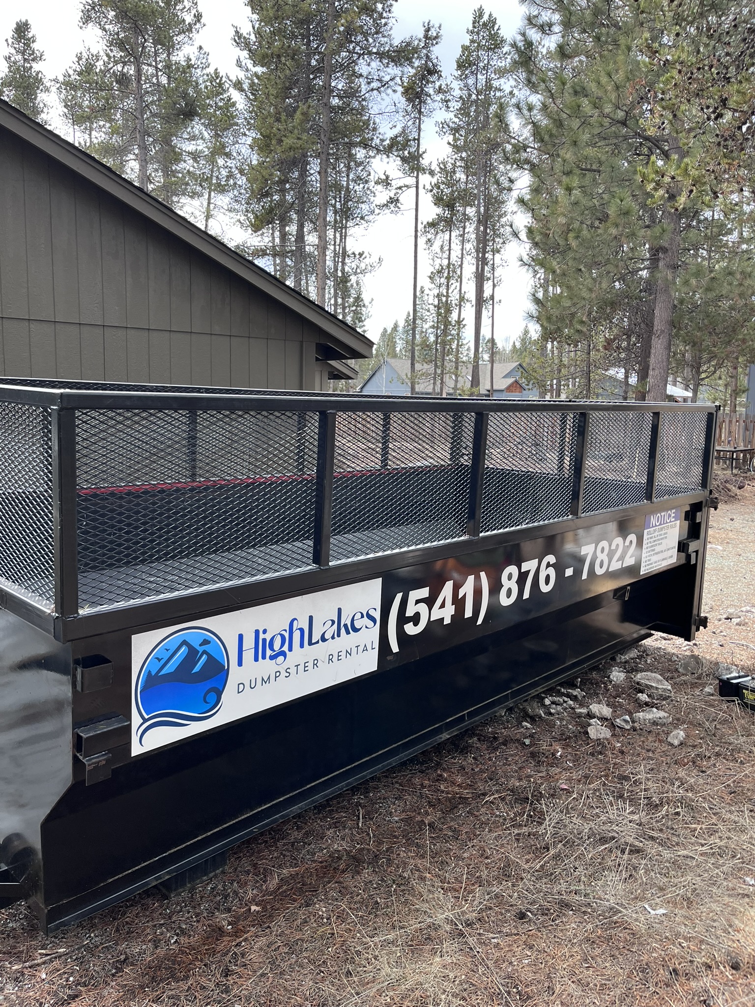 A full dumpster trailer ready for hauling in a residential area.